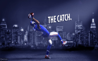 Football player catching ball the - a cityscape in the background free wallpaper