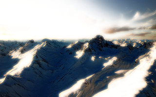 Large mountain snow cloudy sky - a sunbeam in the distance free wallpaper