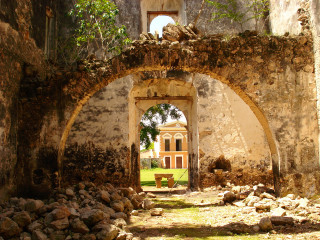 Stone archway bench building clock - a clock tower in the distance free wallpaper