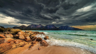 Beach rocky shoreline mountains cloudy - stormy weather free wallpaper