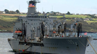 Large gray ship water flag - a hill in the background free wallpaper
