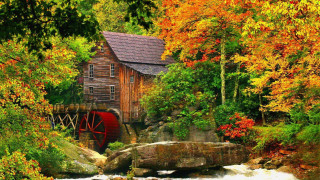 Wooden building river trees rocks - fall foliage free wallpaper