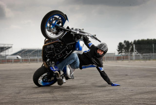 Man wheelie motorcycle parking lot - action pose free wallpaper for desktop