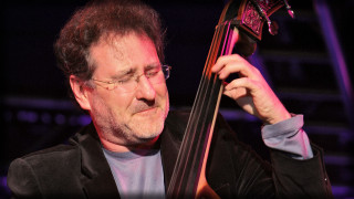 Man holding bass serious look - his right hand free wallpaper