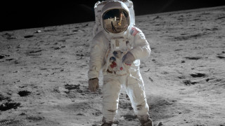 Astronaut standing on moon foot - free space wallpaper