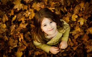Little girl falling leaves smiling - her pocket free wallpaper