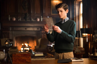 Boy green sweater holding paper - a fireplace free wallpaper