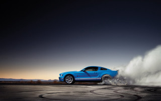Blue mustang driving dusty road - tire free wallpaper