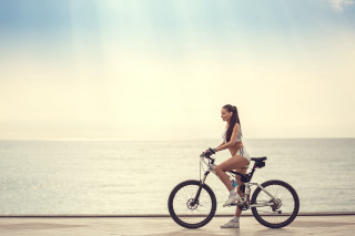 Woman biking ocean sunny day - summer free wallpaper
