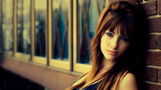 Woman brick wall serious look - a woman leaning against a brick wall free wallpaper