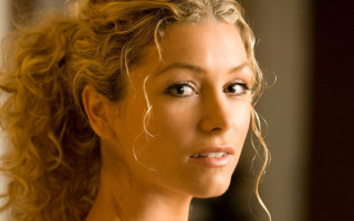 Blonde woman serious blue eyes - her face and shoulders free wallpaper