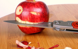 Knife cutting apple face background - an apple free wallpaper
