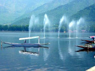 Lake boat water splashing mountain - side and a mountain in the background free wallpaper