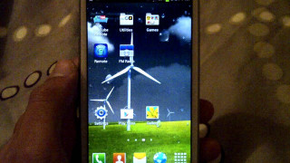 Person holding smartphone windmill screen - a windmill free wallpaper