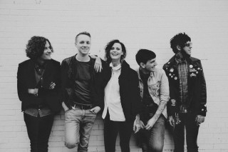 Group people standing brick wall - a brick wall behind them free wallpaper