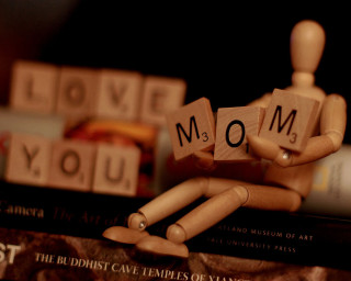 Wooden man holding block mom - a stack of books free wallpaper