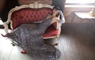 Woman dress couch red chair - a brick wall behind her free wallpaper