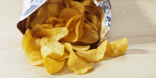 Chips bag and pile on - top of a table free wallpaper