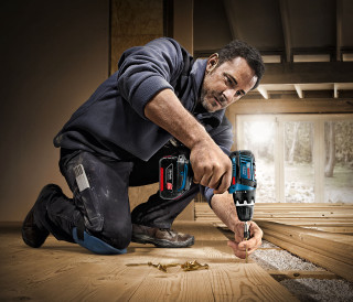 Man working floor drill screwdriver - a floor free wallpaper