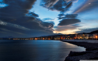 City lit night ocean clouds - stormy weather free wallpaper