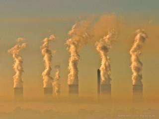 Factory smokestacks emitting distance group - hazy free wallpaper