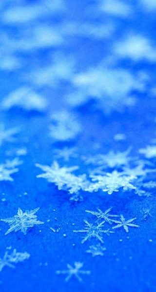 Snowflake closeup blue surface snow - free winter wallpaper for mobile