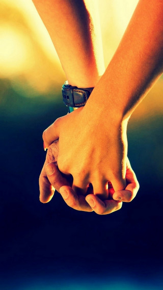 Holding hands blurry background couple - free valentines wallpaper for mobile