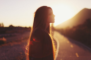 Woman sunset road hair blowing - the sun setting behind her free wallpaper