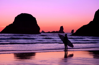 Beach sunset surfboard rock formation 2 - a rock formation in the background free wallpaper