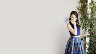 Woman blue dress flower portrait - a white wall behind her free wallpaper
