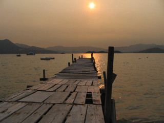Wooden dock boat sunset mountains - a wooden dock free wallpaper