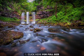 Waterfall rocks foreground forest background - the foreground and a forest in the background free wallpaper
