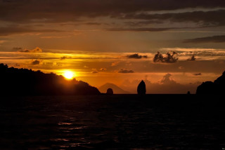 Sunset water mountain boat person - a sunset over a body of water free wallpaper