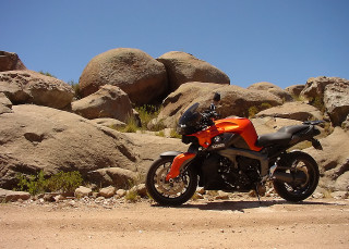 Motorcycle parked rock formation desert - a still life free wallpaper