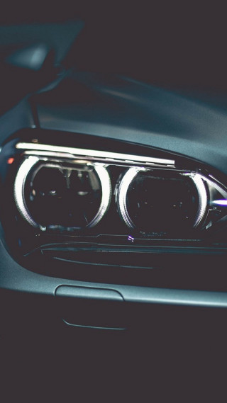 Car headlights closeup dark background - a white light free wallpaper for mobile