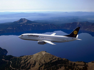 Jetliner flying mountains lake sky - a large jetliner free wallpaper