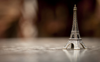 Miniature eiffel tower table blurry - a table top free wallpaper