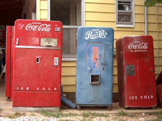 Three old coke machines yellow - a yellow building free wallpaper