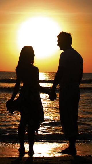 Couple holding hands beach sunset - free sunset wallpaper for mobile