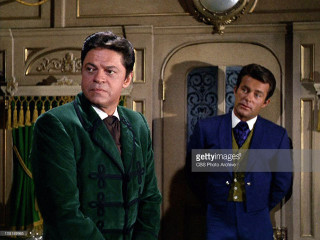 Two men suits room clock - the wall behind them free wallpaper