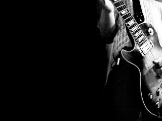 Man holding guitar serious look 3 - grunge free wallpaper