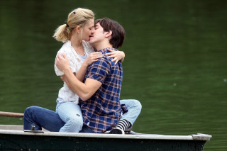 Man woman kissing boat lake - a boat in the background free wallpaper