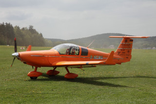 Orange plane green field mountains - free bird wallpaper
