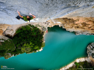 Man jumping cliff lake paraglider - wide len free wallpaper