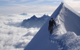 Man climbing snow covered mountain - amazing free wallpaper