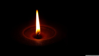 Lit candle dark black background - free light wallpaper