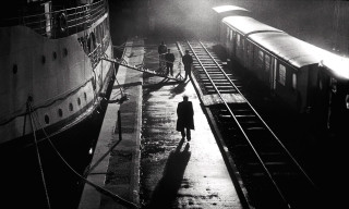 Man walking sidewalk train track - film noir free wallpaper