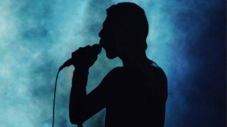 Man holding microphone stage smoke - deep shadow free wallpaper