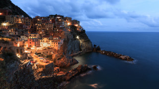 Village cliff ocean nighttime lights - a village free wallpaper