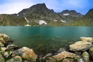 Mountain lake cliffs green forest - a few snow free wallpaper